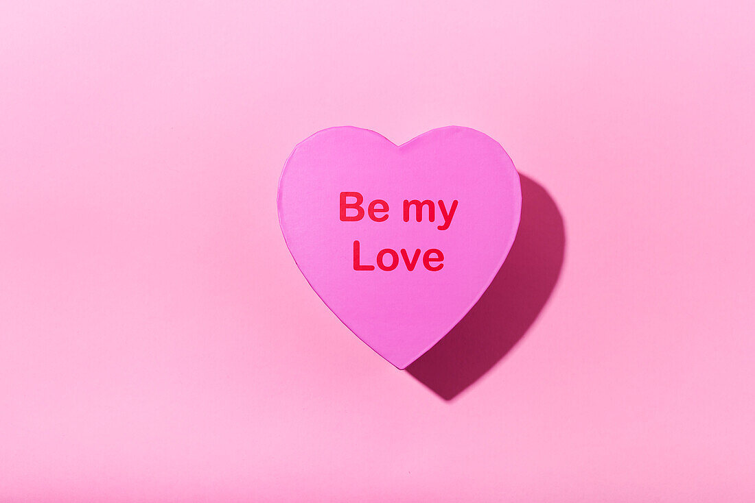 Heart-shaped box on pink background