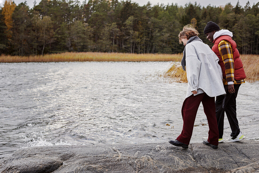 Friends standing on rocky lakeshore