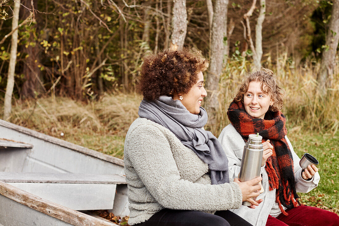 Female friends drinking from insulated drink container