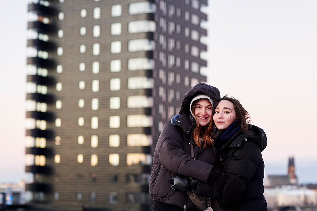 Portrait of smiling female couple against apartment block
