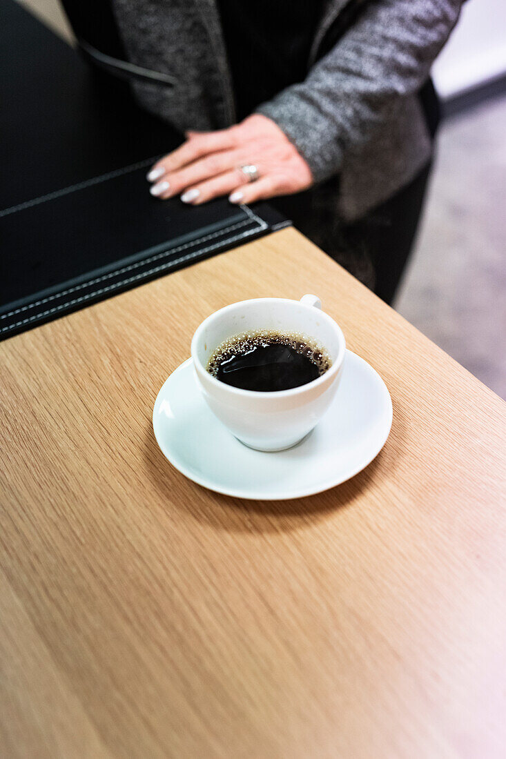 Tasse mit schwarzem Kaffee auf dem Schreibtisch