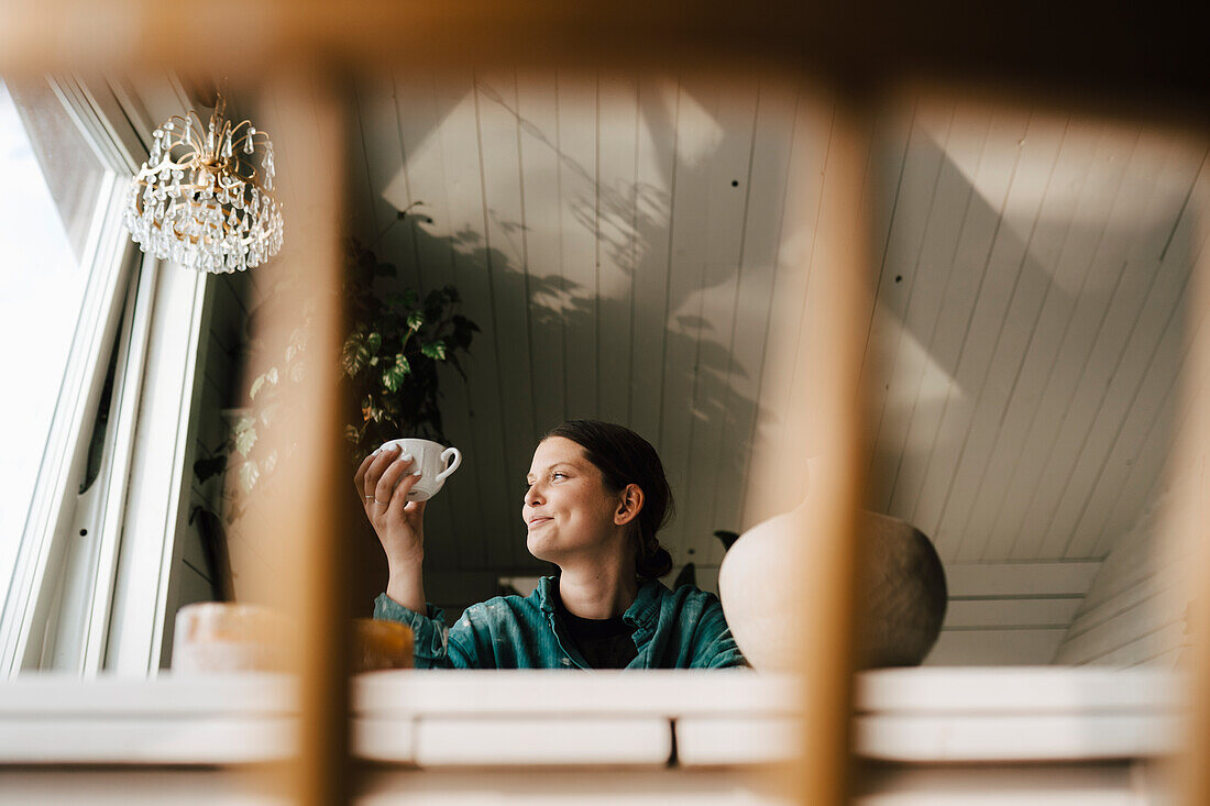 Young woman drinking coffee at home