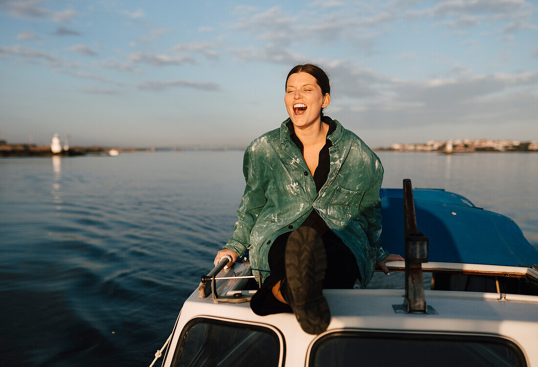 Smiling young woman sitting on motorboat