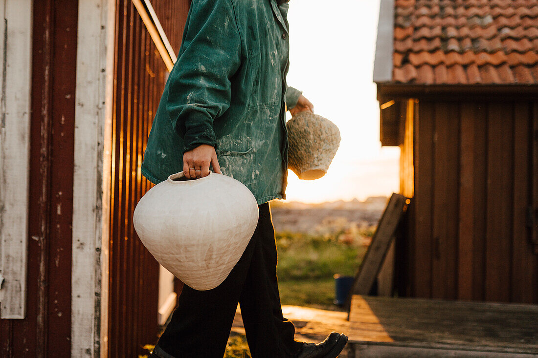 Young woman carrying handmade vases