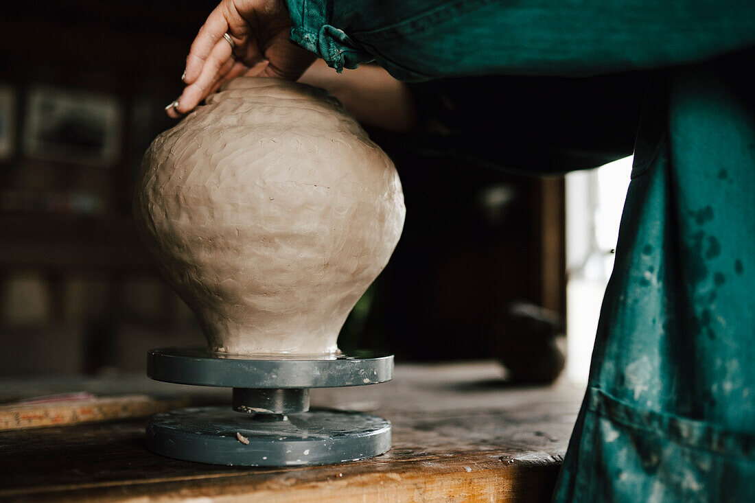 Töpferin beim Herstellen einer Vase in der Werkstatt