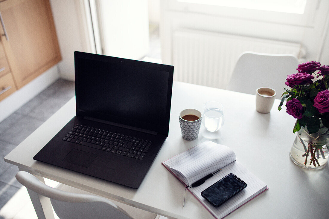 Laptop und Tagebuch auf dem Küchentisch