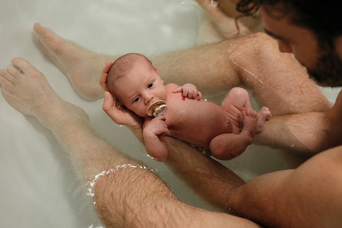 Vater nimmt Bad mit neugeborenem Baby