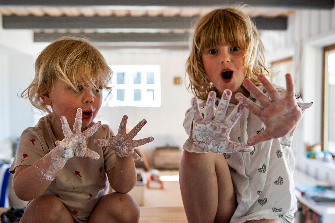 Girl and boy showing messy white hands