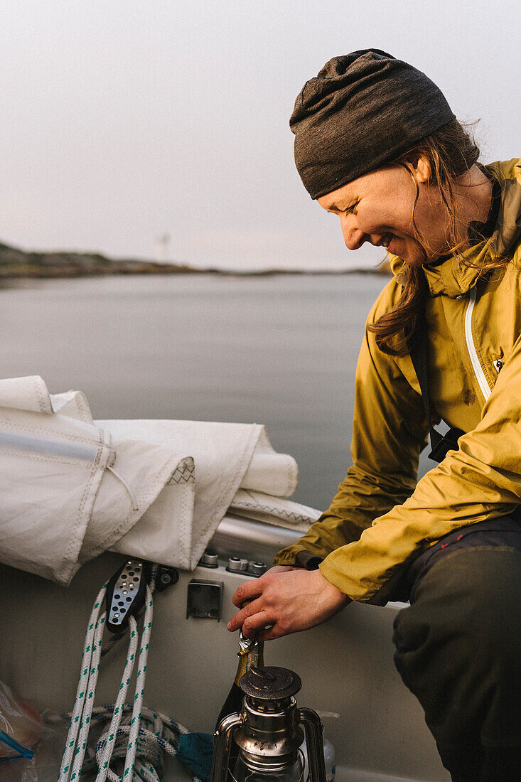 Smiling woman using camping stove on boat