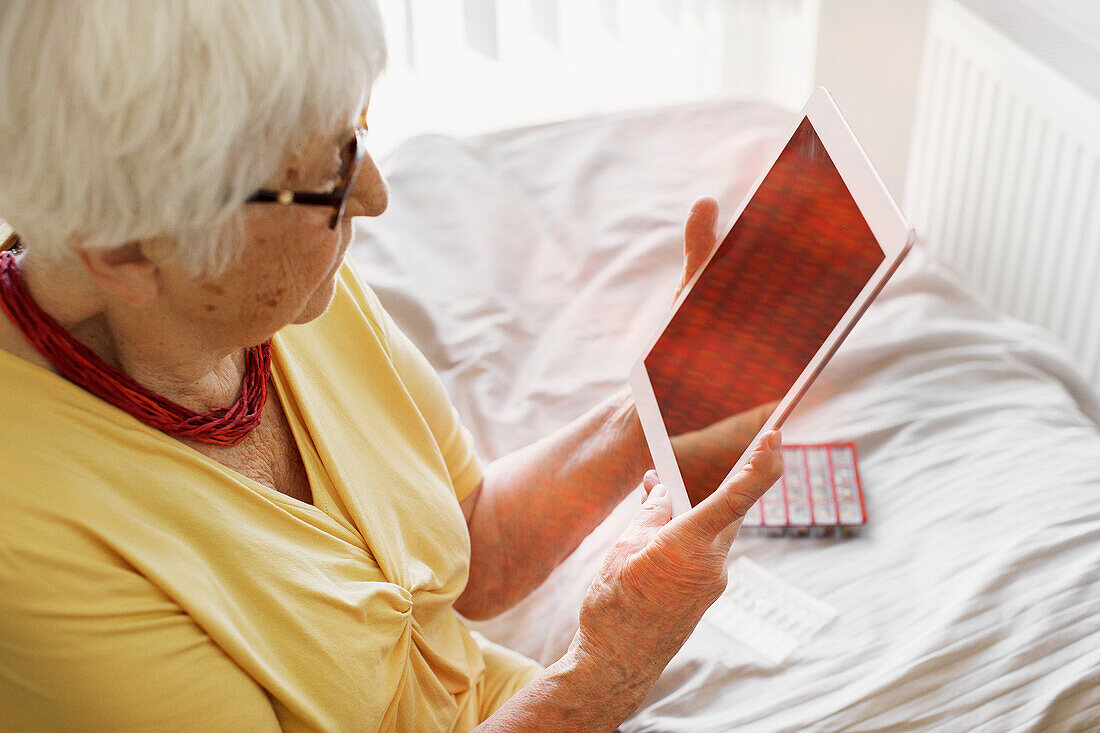 Ältere Frau mit digitalem Tablet