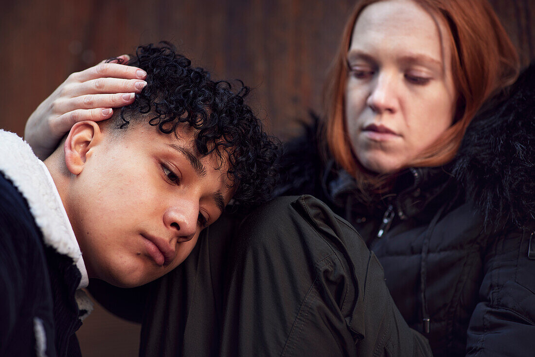 Young woman touching and comforting boy