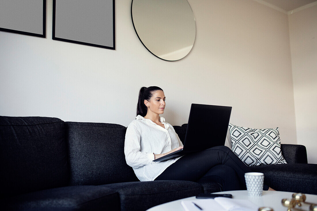 Woman on sofa using laptop