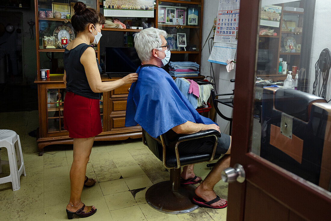 Senior man getting haircut in hair salon