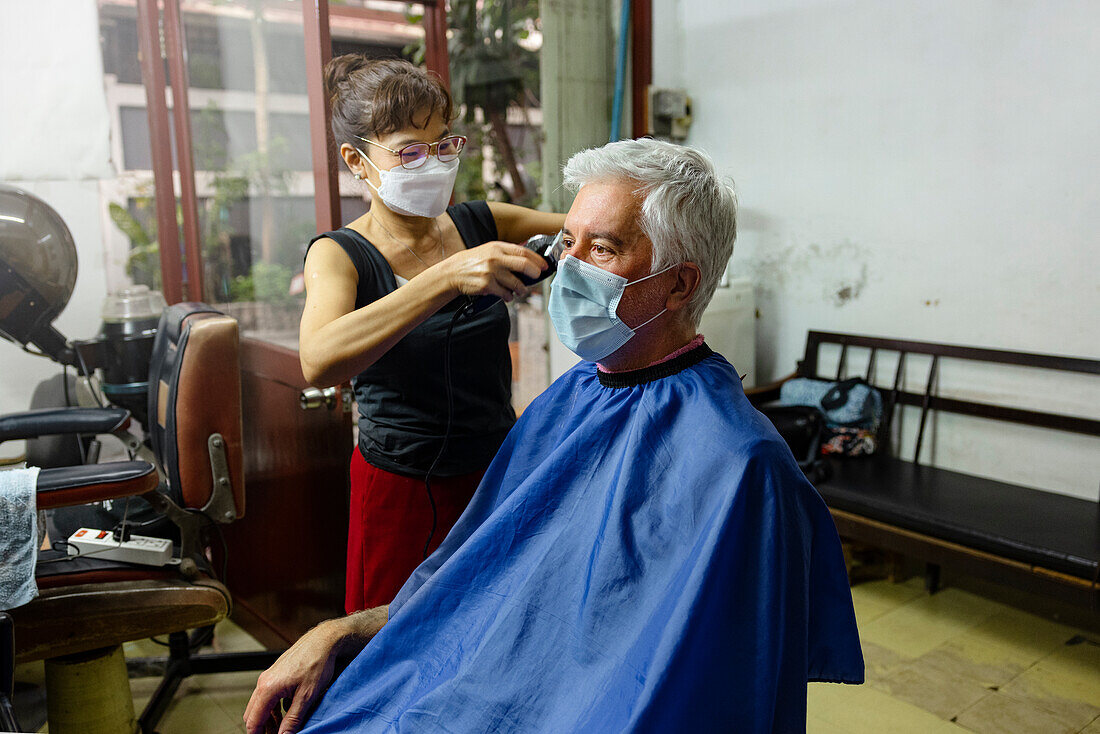 Älterer Mann lässt sich im Friseursalon die Haare schneiden