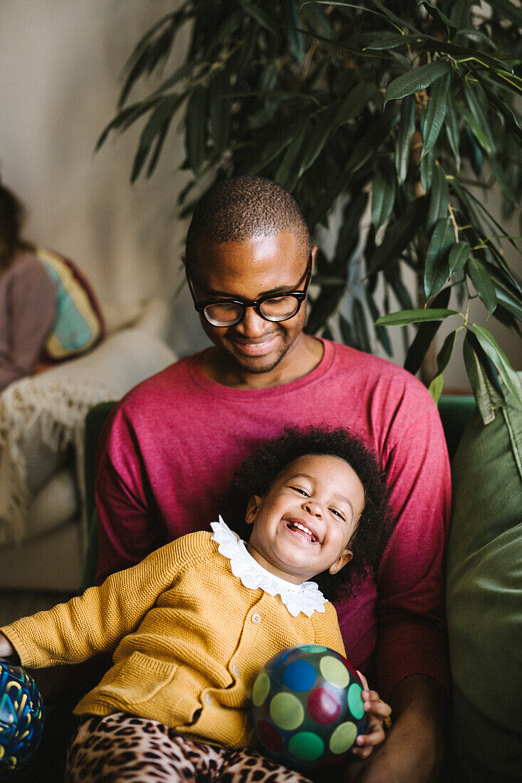 Smiling father and daughter relaxing at home