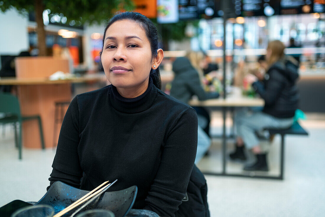 Portrait of young woman sitting in restaurant