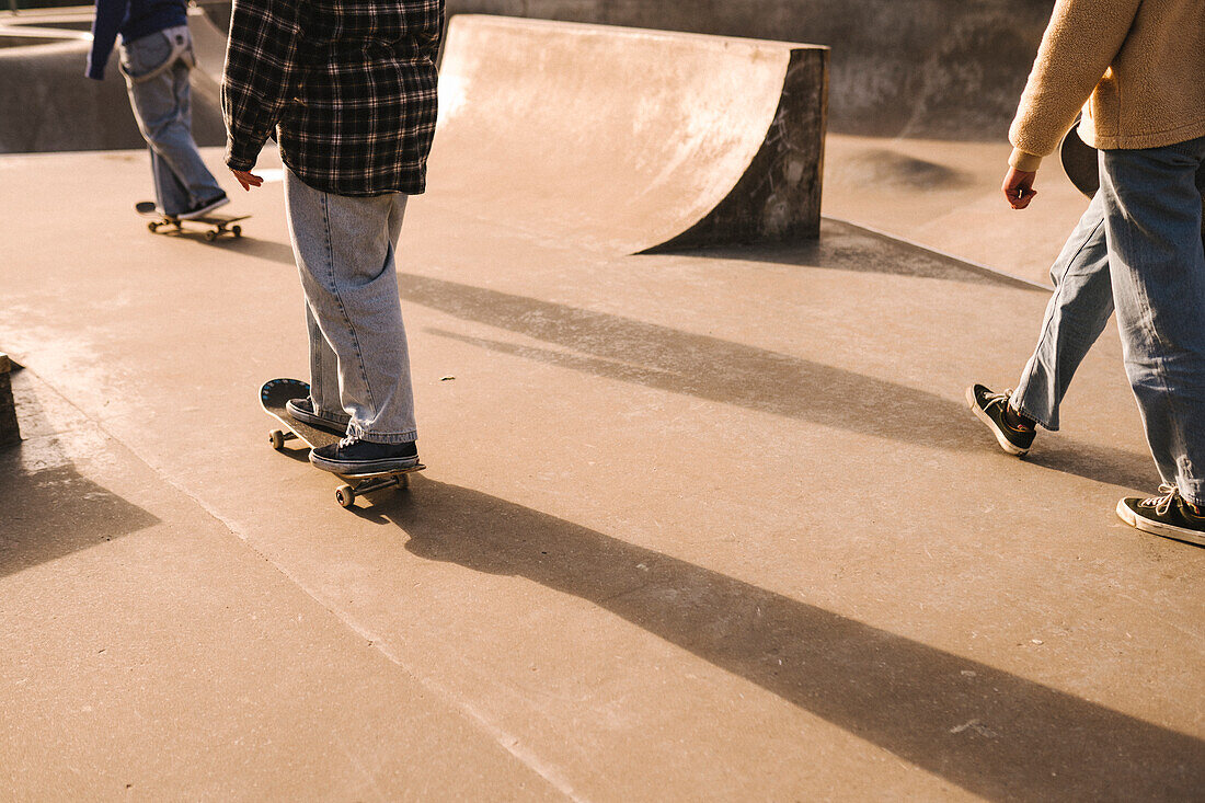 Teenage girls skateboarding in skatepark