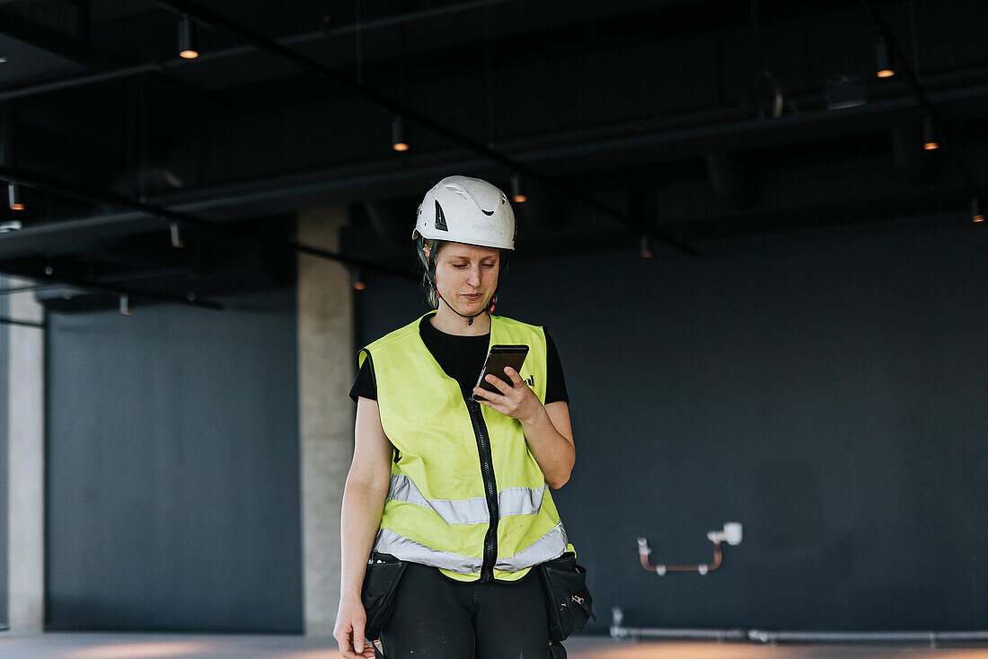 Worker at construction site using cell phone