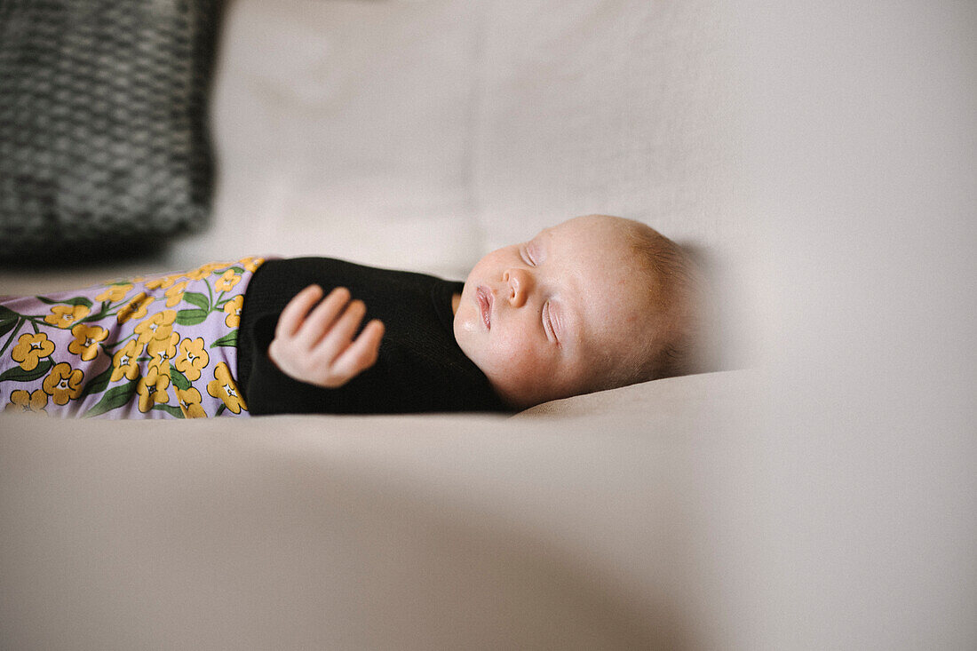 Newborn baby sleeping on sofa