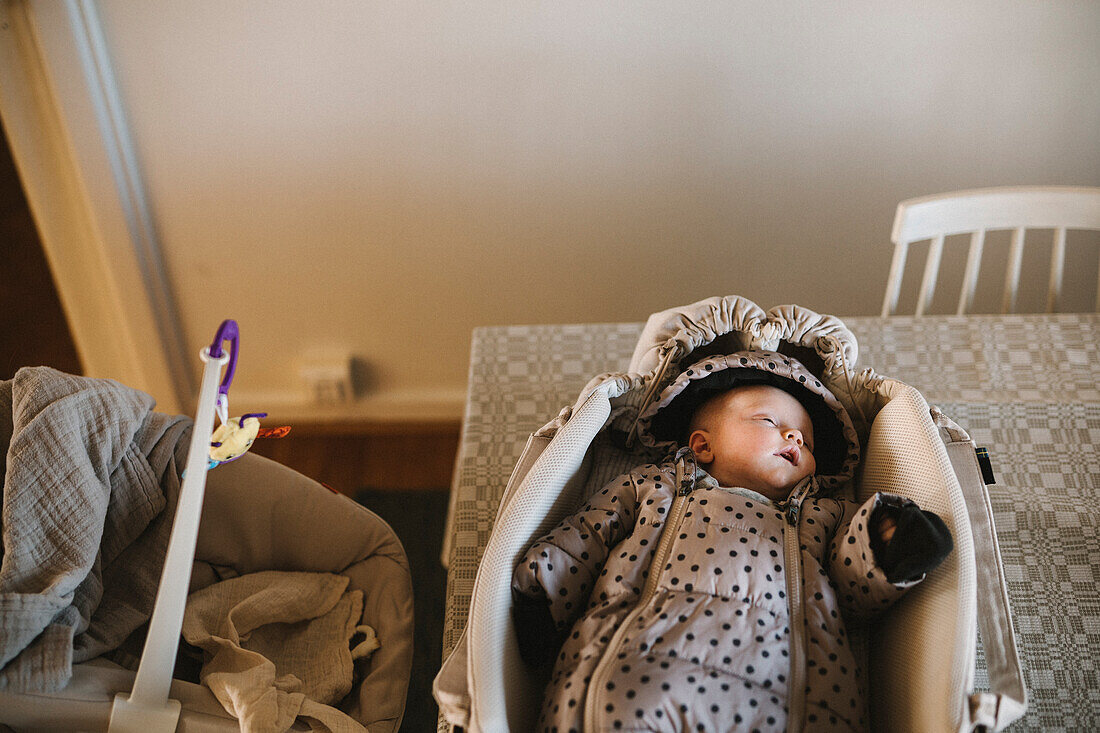 Newborn baby lying in stroller cot