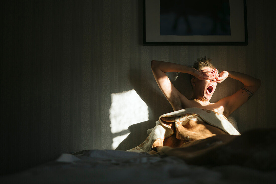 Man waking up in bed