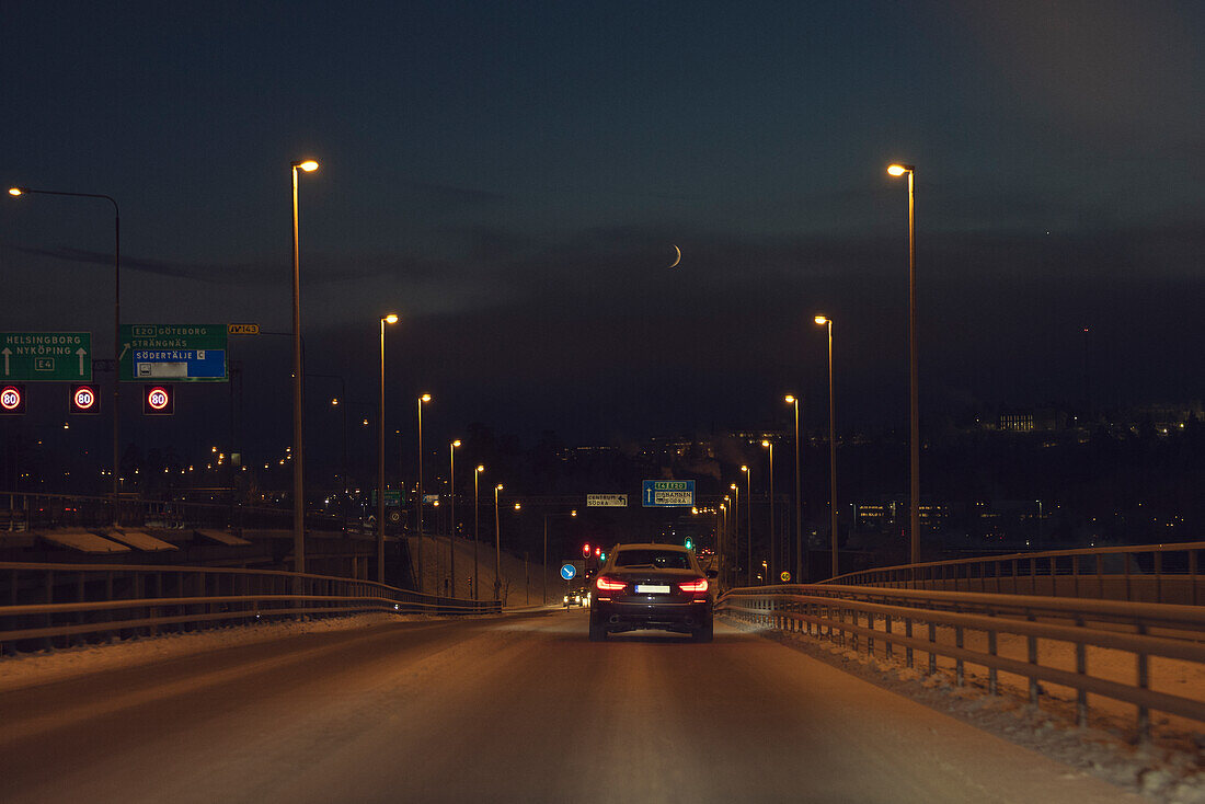 Auto auf Landstraße im Winter bei Nacht