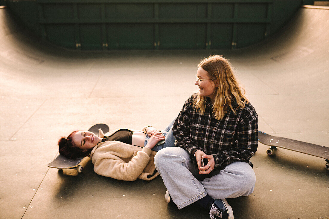 Teenager-Mädchen mit Skateboards entspannen sich im Skatepark