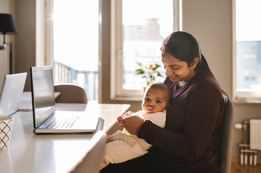 Mother with baby working from home