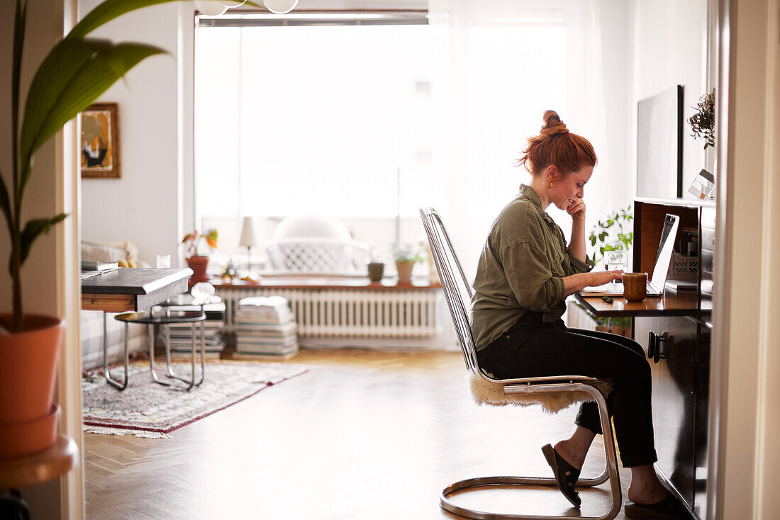 Woman using laptop in living room