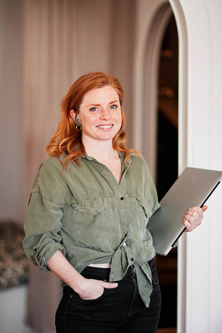 Smiling woman holding laptop