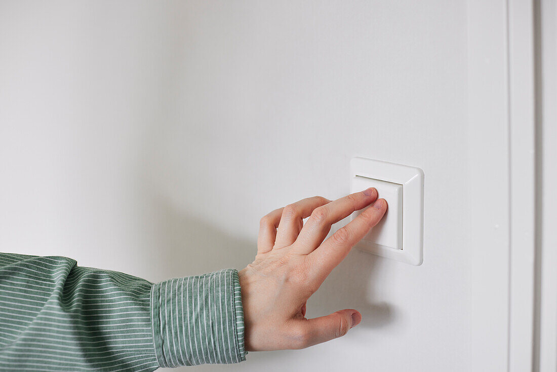 Hand pressing light switch
