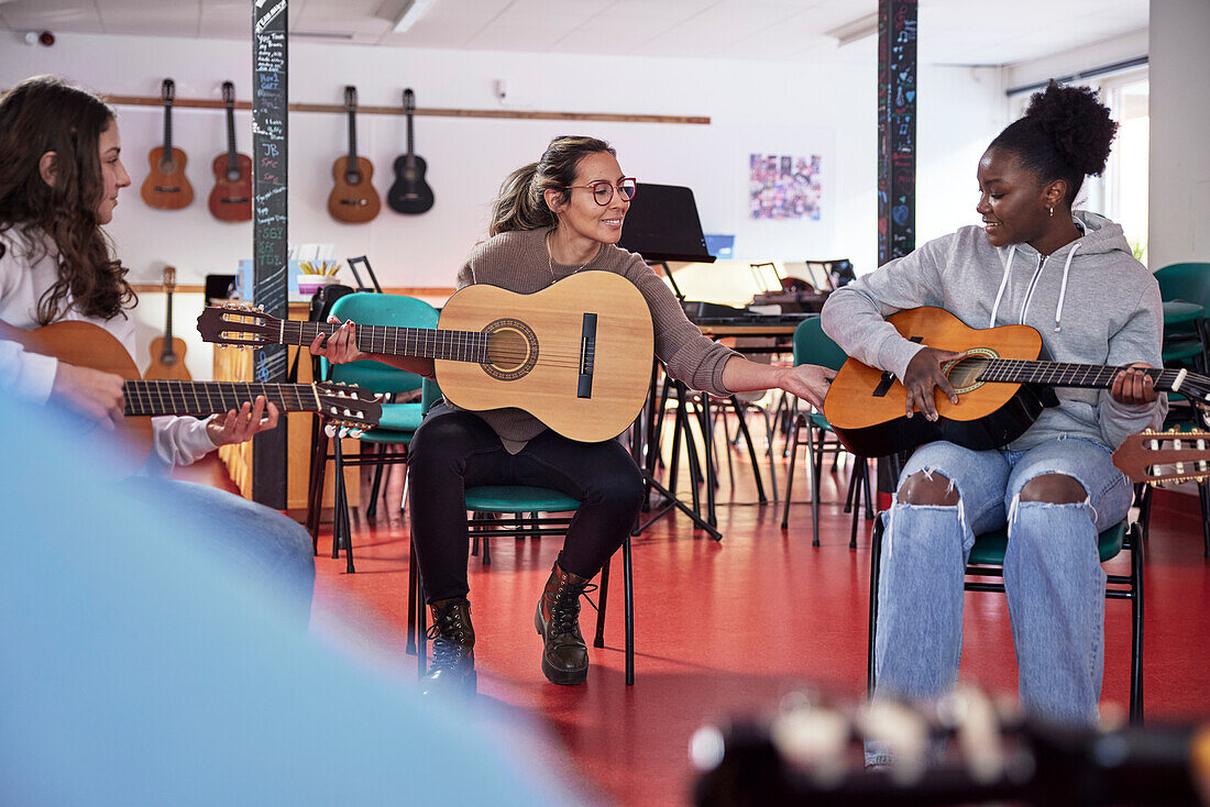 Teenagers attending guitar lesson