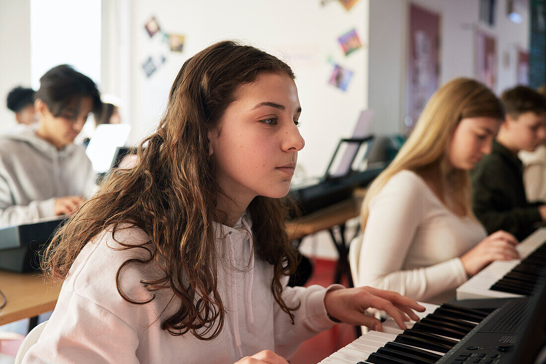 Teenagers attending keyboard lesson