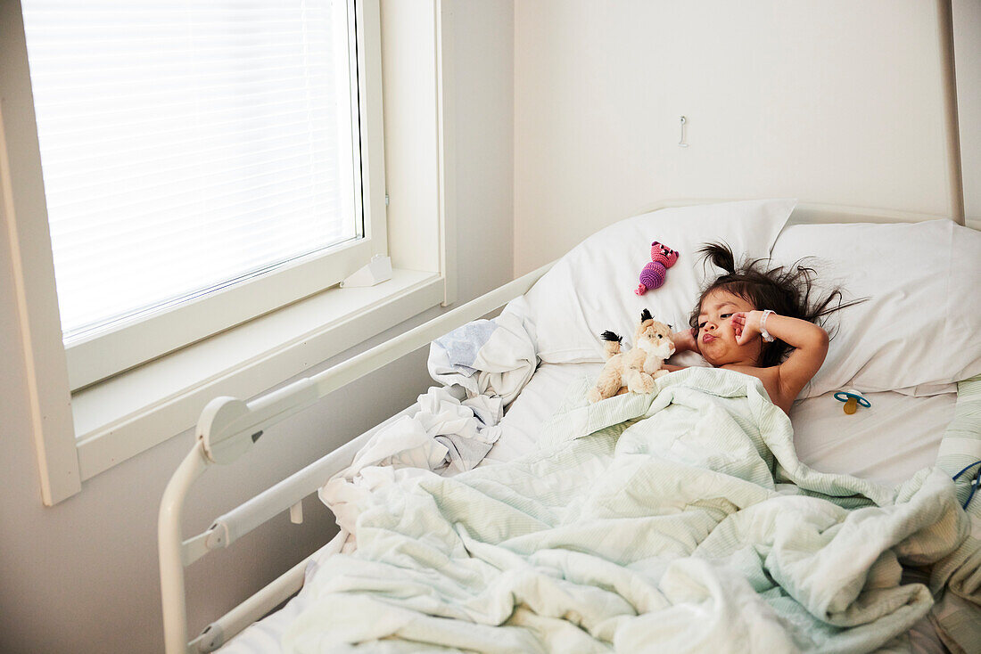 Mädchen liegend im Krankenhausbett