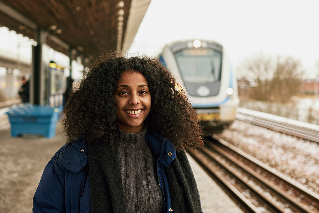 Smiling woman standing at train station