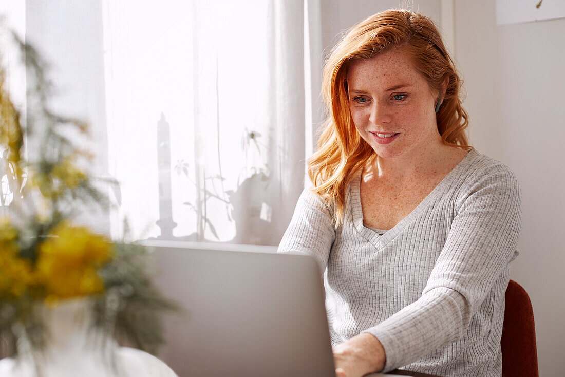 Frau benutzt Laptop zu Hause