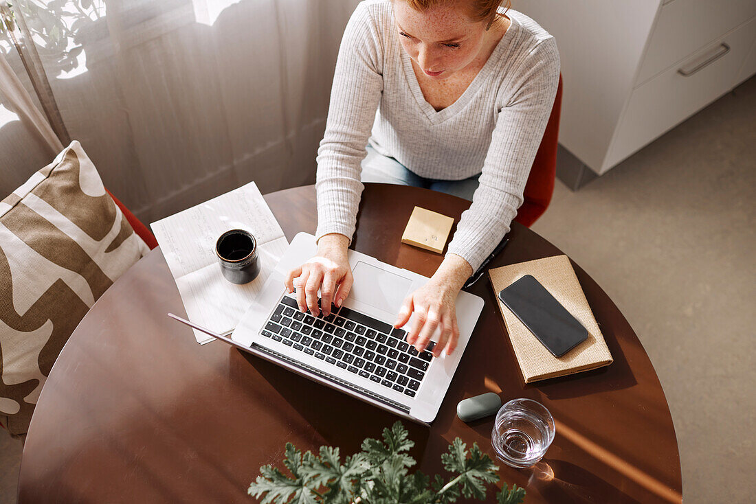 Frau benutzt Laptop zu Hause