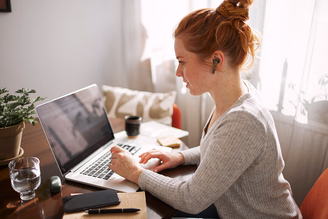 Frau benutzt Laptop zu Hause