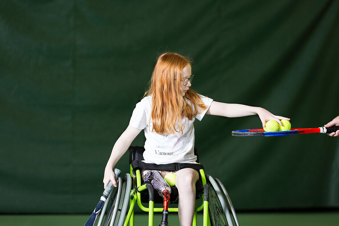 Mädchen im Rollstuhl spielt Tennis