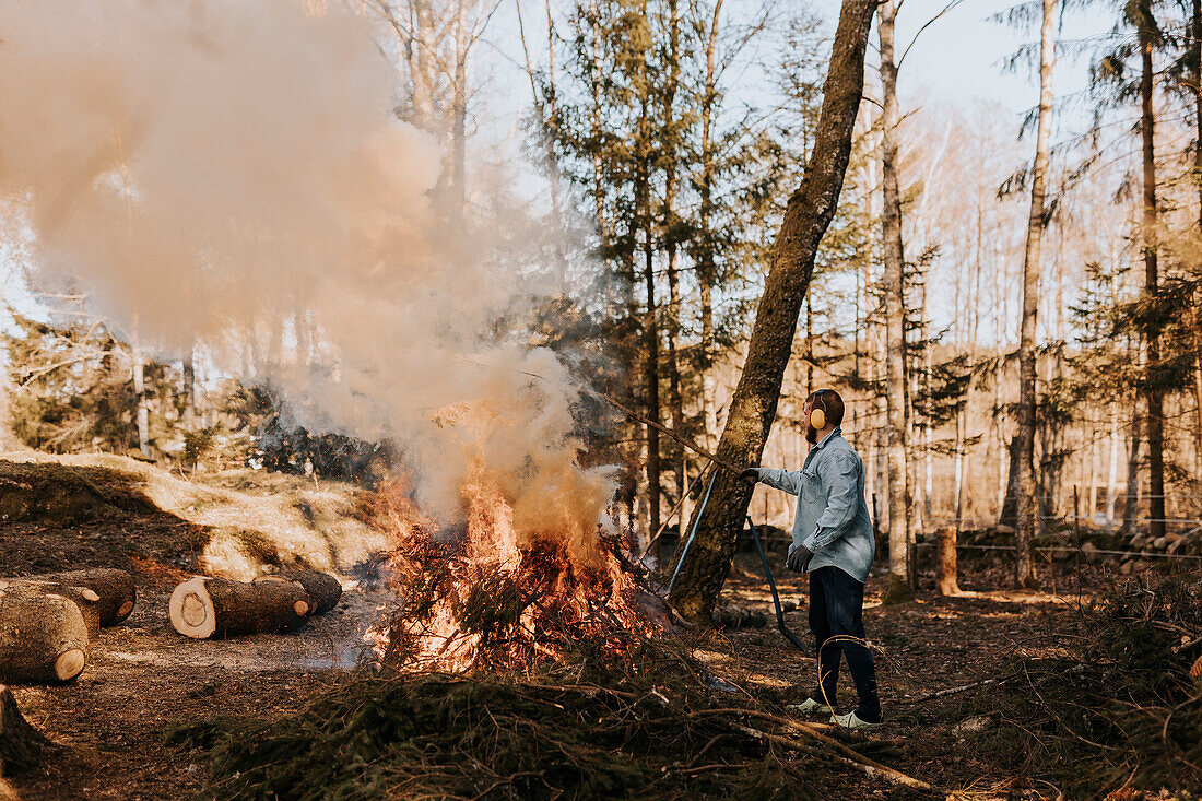 Mann verbrennt Äste im Wald