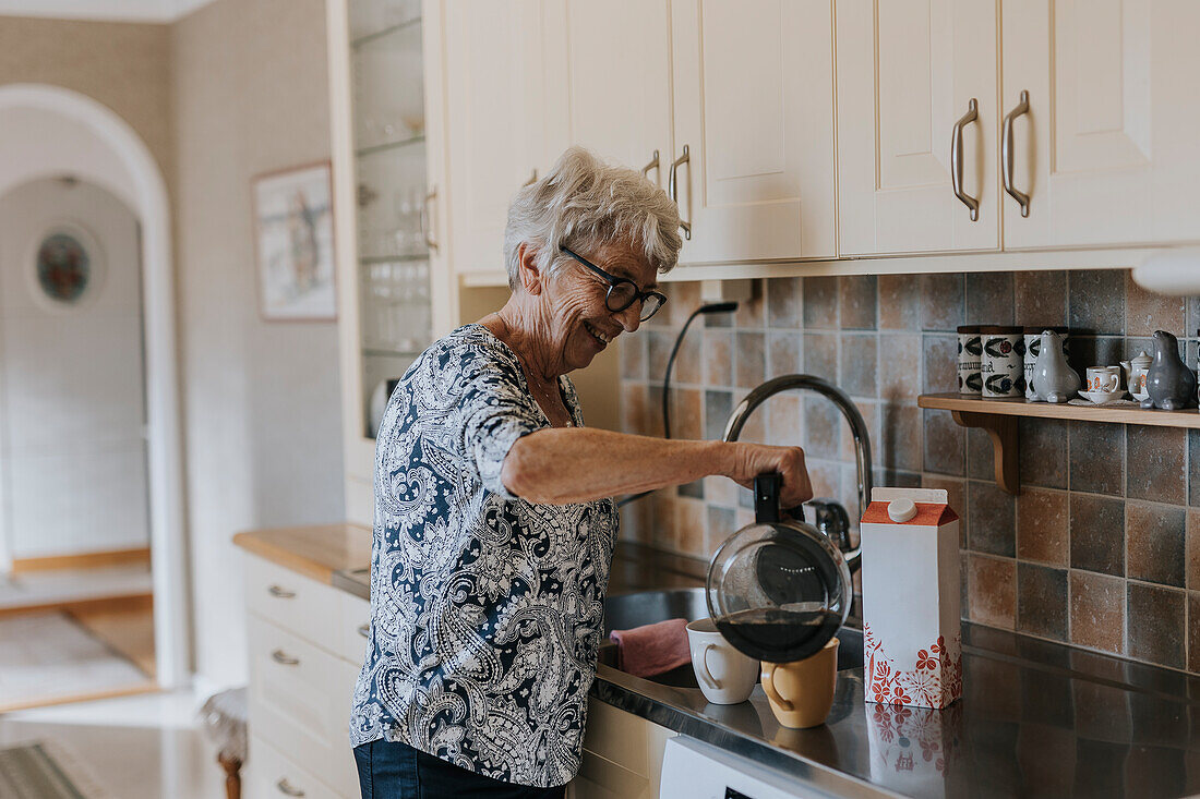 Senior woman in kitchen preparing coffee