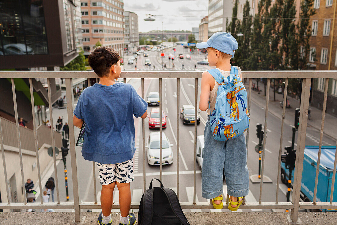Kinder auf dem Viadukt stehend und auf den Verkehr schauend