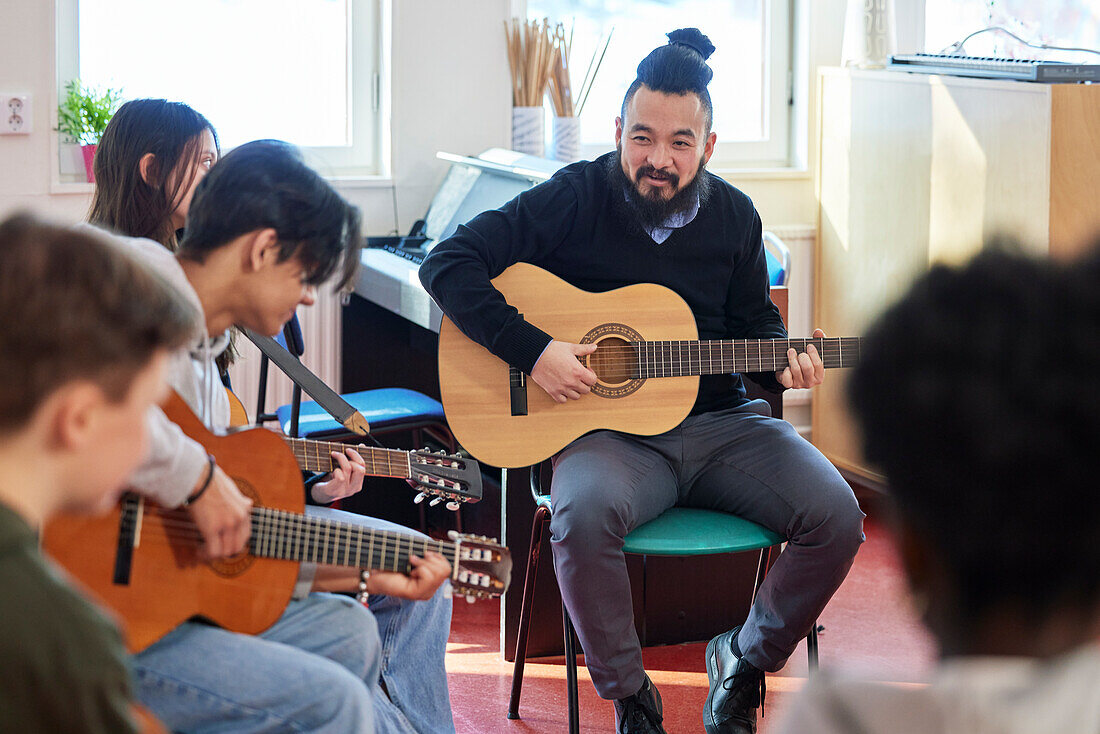 Teenager beim Gitarrenunterricht