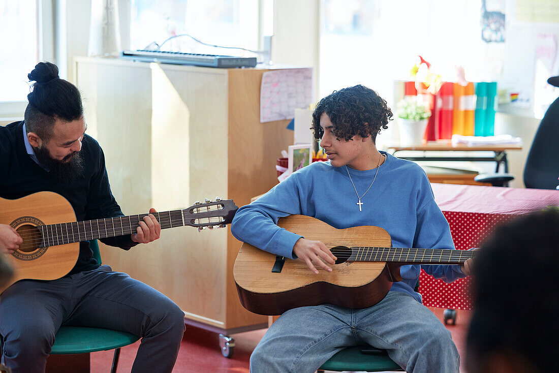 Teenager beim Gitarrenunterricht