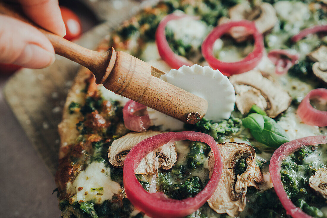 Hand cutting homemade pizza