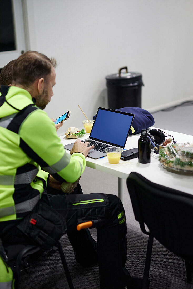 Mann mit Laptop in der Kantine