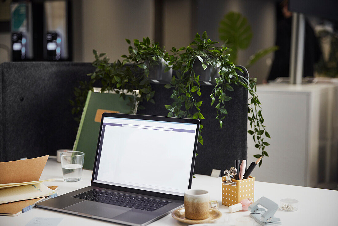 Blick auf den Schreibtisch mit Laptop und Kaffeetasse