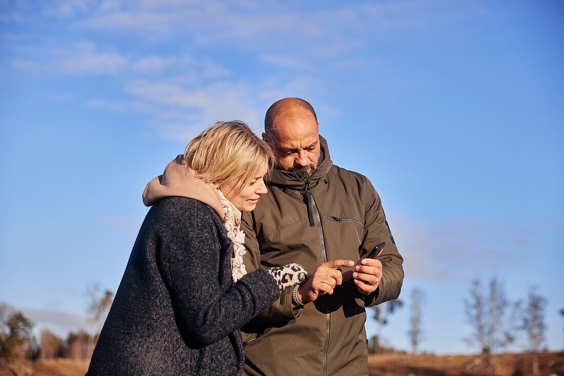 Couple looking at smartphone outdoors