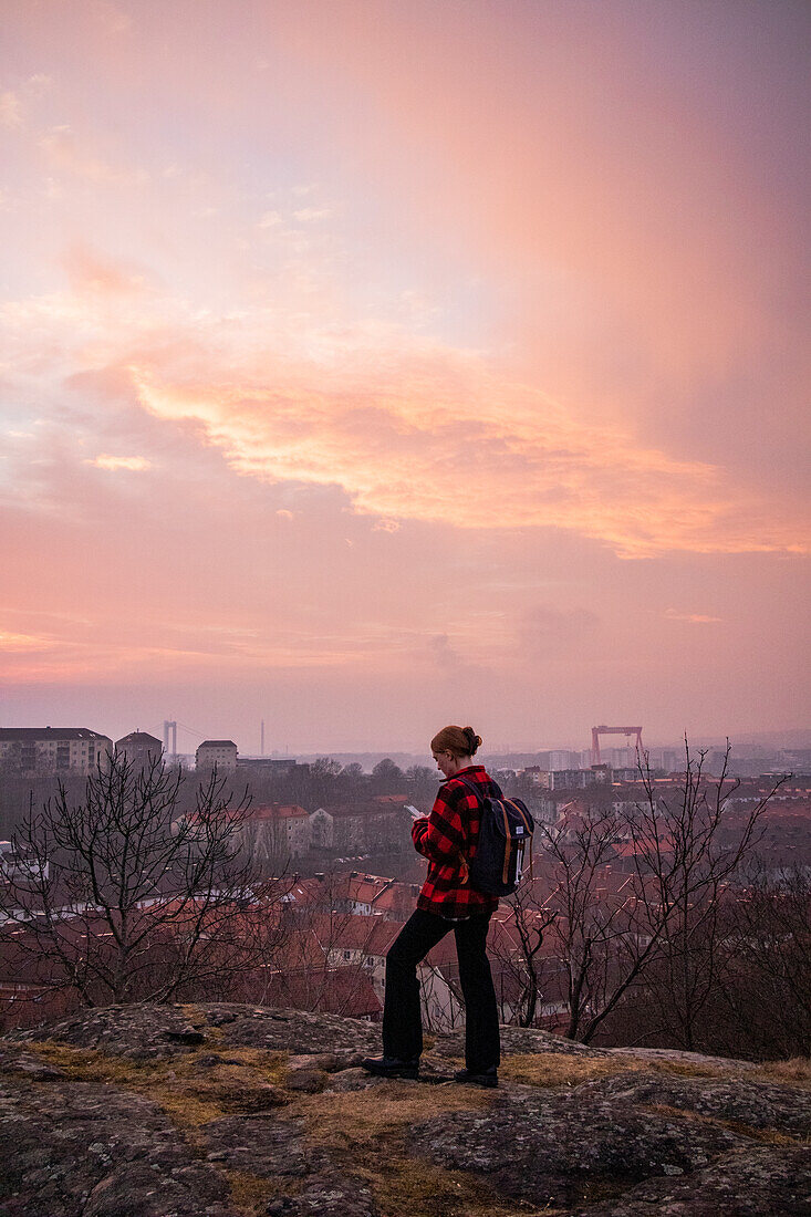 Frau bei Sonnenuntergang mit Mobiltelefon