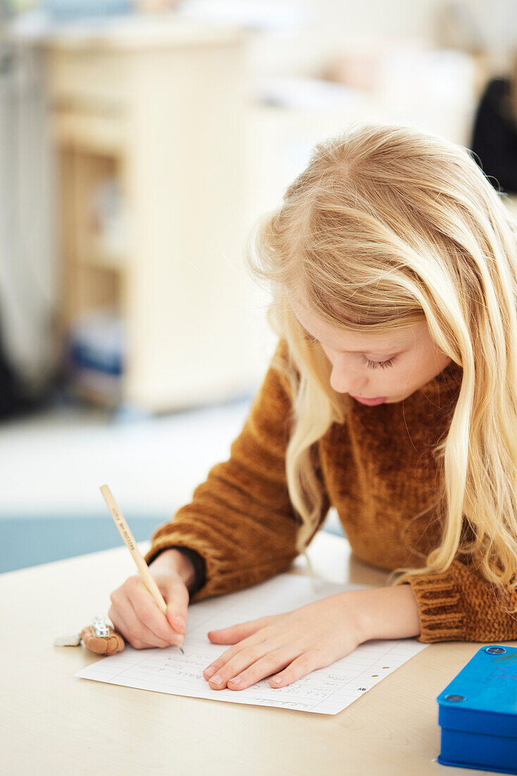 Mädchen, das in der Schule eine Schreibaufgabe erledigt